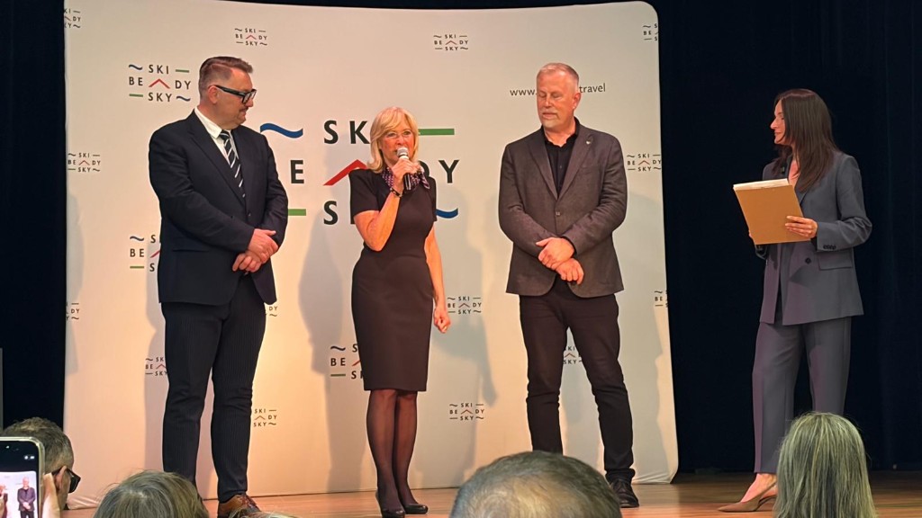 Štyria zástupcovia na pódiu počas osláv 25. výročia Euroregiónu Beskydy pri pozadí s logom Beskidy