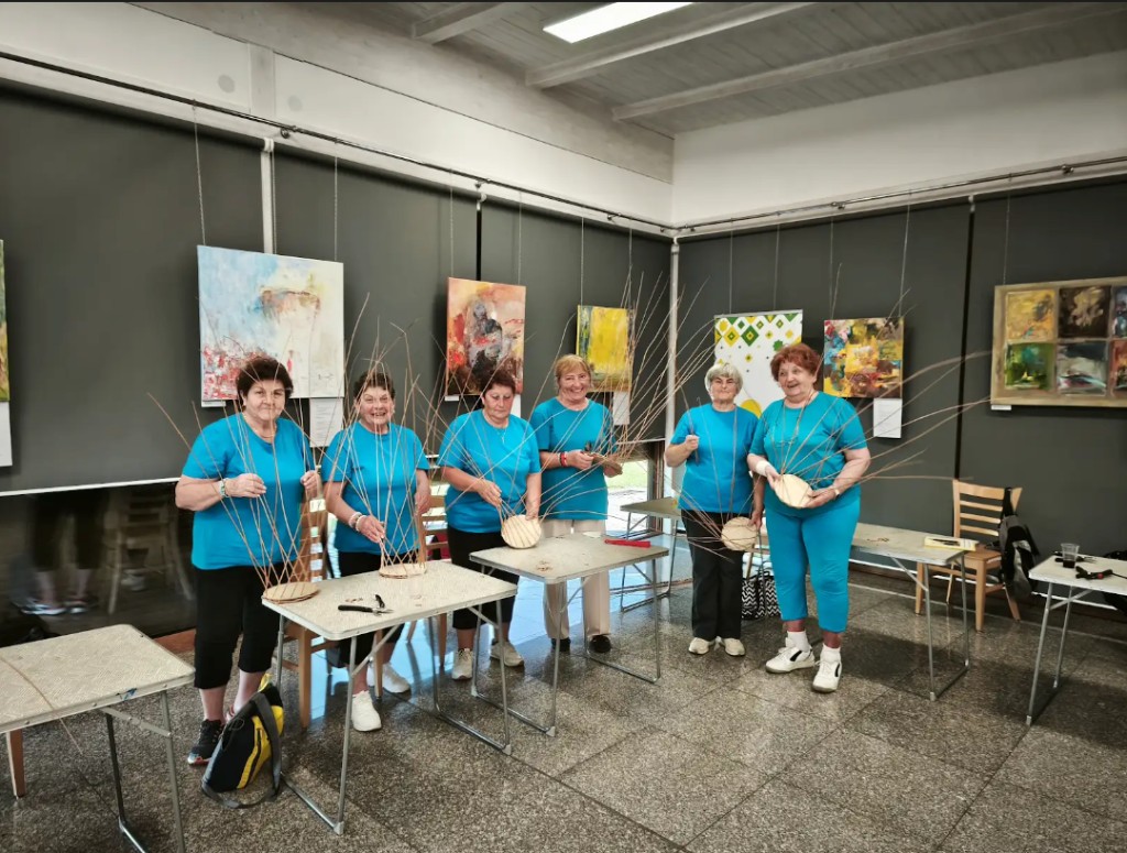 Šesť účastníčok prezentuje svoje ručne vyrobené košíky z prútia na workshope Folkowe Pogranicze v Jasienici