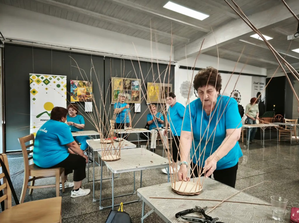 Účastníčka workshopu tradičného pletenia z prútia pracuje s vŕbovými prútmi v Jasienici počas projektu Folkowe Pogranicze