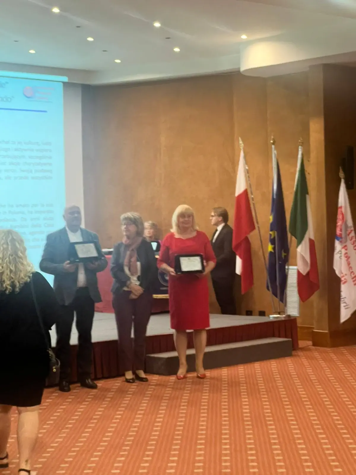 Odovzdávanie ocenení na pódiu pri vlajkách
