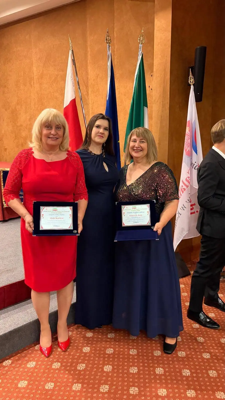 Tri účastníčky s oceneniami pri vlajkách